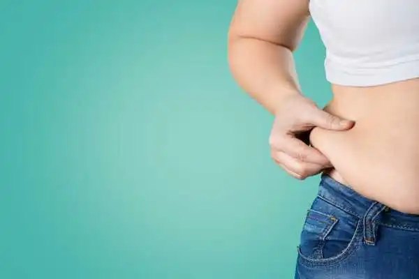 Image of woman pinching her love handles to show weight gain Sleaford